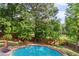 Sparkling in-ground pool surrounded by lush greenery and a wooden fence at 1300 Sever Woods Dr, Lawrenceville, GA 30043