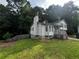 Exterior view of the property with mature trees and a sloped lawn at 1504 Colt Ridge Se Ln, Mableton, GA 30126