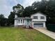 Split level home showcasing light siding, a front-facing garage, and a lawn at 1504 Colt Ridge Se Ln, Mableton, GA 30126