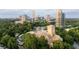 Aerial view of a church surrounded by lush greenery with the city skyline as a backdrop at 2795 Peachtree Ne Rd # 2101, Atlanta, GA 30305