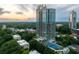 Stunning aerial view of a high-rise building with pool and tennis court, surrounded by lush greenery at sunset at 2795 Peachtree Ne Rd # 2101, Atlanta, GA 30305