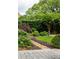 Stone path through the lush backyard, accented by flowering plants and manicured hedges at 2795 Peachtree Ne Rd # 2101, Atlanta, GA 30305