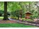 Serene backyard features a charming wooden playhouse surrounded by trees and natural landscaping at 2795 Peachtree Ne Rd # 2101, Atlanta, GA 30305