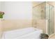 Bathroom featuring a modern bathtub with a glass-walled shower and neutral-colored tiling at 2795 Peachtree Ne Rd # 2101, Atlanta, GA 30305