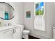 Clean bathroom with a white vanity, decorative mirror, and natural light from a nearby window at 3481 Landen Pine Ne Ct, Atlanta, GA 30305