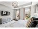 Primary bedroom with a tray ceiling, decorative lighting, and large windows with tree views at 3481 Landen Pine Ne Ct, Atlanta, GA 30305