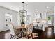 Open dining area with modern light fixture, adjacent to a kitchen with white cabinetry and island seating at 3481 Landen Pine Ne Ct, Atlanta, GA 30305