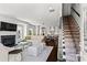 Open-concept living room with fireplace, dark wood floors, neutral decor, and adjacent staircase to the upper level at 3481 Landen Pine Ne Ct, Atlanta, GA 30305