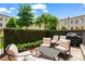 Outdoor patio area with comfortable seating and a grill, surrounded by lush greenery and privacy hedges at 3481 Landen Pine Ne Ct, Atlanta, GA 30305