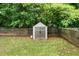 Backyard shed in fenced in yard with brown wood double doors and a grey roof at 6378 Grey Fox Way, Riverdale, GA 30296