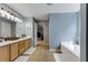 Well-lit bathroom with tile flooring, a soaking tub and wood vanity at 6378 Grey Fox Way, Riverdale, GA 30296
