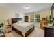 Comfortable bedroom with a dark wood bed frame, a large window, and bright, sunny walls at 6378 Grey Fox Way, Riverdale, GA 30296