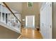 Bright foyer with hardwood floors, a staircase with white banister, and large windows at 6378 Grey Fox Way, Riverdale, GA 30296