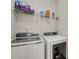 Convenient laundry room featuring a front loading washer and dryer with overhead wire shelving at 6378 Grey Fox Way, Riverdale, GA 30296