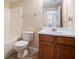 Cozy bathroom with a tub/shower combo, white toilet and wooden vanity at 115 Manx Dr, Grantville, GA 30220
