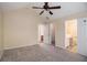 Spacious carpeted bedroom featuring a ceiling fan and ensuite bathroom access at 115 Manx Dr, Grantville, GA 30220