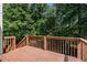 Wooden deck with railing, offering a view of the lush greenery at 115 Manx Dr, Grantville, GA 30220