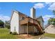 Exterior angle of two-story house with a deck and a stone fire pit in the backyard at 115 Manx Dr, Grantville, GA 30220