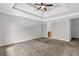 Spacious bedroom featuring a tray ceiling and ceiling fan at 4115 Kensington Cv, Atlanta, GA 30349