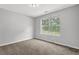A bedroom with carpet and a window offering a view of trees at 4115 Kensington Cv, Atlanta, GA 30349
