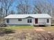 Welcoming home featuring vinyl siding, metal roof, gray trim and a cozy front porch and a small yard at 7301 Staton Se Pl, Acworth, GA 30102