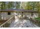 An eye-level view of the back deck and rear side of the home, surrounded by trees, exhibiting the potential outdoor living space at 12 Woodland St, Dallas, GA 30157