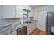Bright kitchen featuring white cabinets, stainless steel dishwasher, and elegant marble countertops at 12 Woodland St, Dallas, GA 30157