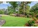 Expansive backyard with verdant lawn, mature trees and border plants provides a private outdoor oasis at 2500 Madison Commons, Atlanta, GA 30360