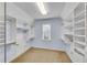 Large walk-in closet with custom shelving, storage and a window for natural light at 2500 Madison Commons, Atlanta, GA 30360