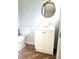 Cozy bathroom featuring a toilet, vanity with storage, and decorative circular mirror at 4274 Carrollwood Dr, Stone Mountain, GA 30083