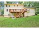 View of backyard with a two-story home featuring a wooden deck and stairs leading to a green lawn at 5141 Rocky Run, Stone Mountain, GA 30088