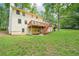 The home's backyard offers a two-story design, a wooden deck with steps, and a lush lawn at 5141 Rocky Run, Stone Mountain, GA 30088