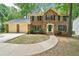 Charming brick two-story home with a two-car garage and a well-manicured lawn at 5141 Rocky Run, Stone Mountain, GA 30088