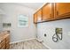 Functional laundry room featuring wood-look flooring, overhead cabinets, and convenient utility connections at 5141 Rocky Run, Stone Mountain, GA 30088