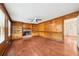 Cozy living room featuring wood paneling, hardwood floors, and a brick fireplace at 5141 Rocky Run, Stone Mountain, GA 30088