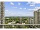 Scenic balcony view showcasing lush green trees, other highrise condominiums, and blue skies at 195 14Th Ne St # 1706, Atlanta, GA 30309