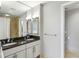 Bathroom featuring dual sinks, granite countertops, and a large mirror with decorative lighting at 195 14Th Ne St # 1706, Atlanta, GA 30309