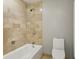 Contemporary bathroom showcasing a white bathtub with tiled surround and white toilet at 195 14Th Ne St # 1706, Atlanta, GA 30309