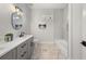 Bathroom with marble floors, gray vanity, white countertop, a sleek mirror, and a tub at 2018 Presley Ne Way, Atlanta, GA 30317