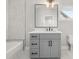 Modern bathroom featuring a gray vanity with a white countertop, a sleek mirror, and a tub at 2018 Presley Ne Way, Atlanta, GA 30317