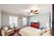 Inviting bedroom with a ceiling fan, wood floors, and comfortable seating area with large windows at 2668 Kings Way, Lawrenceville, GA 30044