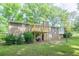 Back of a brick home featuring a wooden deck and a well-maintained lawn with shade trees at 2668 Kings Way, Lawrenceville, GA 30044