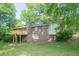 Brick home featuring a wooden deck, mature trees, and a well-maintained lawn at 2668 Kings Way, Lawrenceville, GA 30044