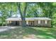 Charming brick home featuring a covered carport and a well-manicured lawn with mature trees at 2668 Kings Way, Lawrenceville, GA 30044