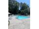 Beautiful community pool surrounded by lounge chairs and lush trees, offering a perfect spot for relaxation and recreation at 3474 Washington Way, Atlanta, GA 30340