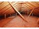 An attic space displaying exposed wooden beams and pink insulation, offering potential storage at 3594 Saddlebrook Dr, Loganville, GA 30052