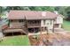 Aerial view of the home with a deck, covered patio, well-maintained lawn, and mature trees at 3594 Saddlebrook Dr, Loganville, GA 30052