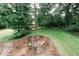 Aerial view of the backyard with a fire pit, seating area, and lush green space surrounded by trees at 3594 Saddlebrook Dr, Loganville, GA 30052