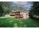 Expansive backyard view showcasing a deck, covered patio, fire pit area, and mature trees at 3594 Saddlebrook Dr, Loganville, GA 30052