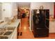 A well-lit kitchen showcasing wood-look tile flooring and a large, modern black refrigerator at 3594 Saddlebrook Dr, Loganville, GA 30052